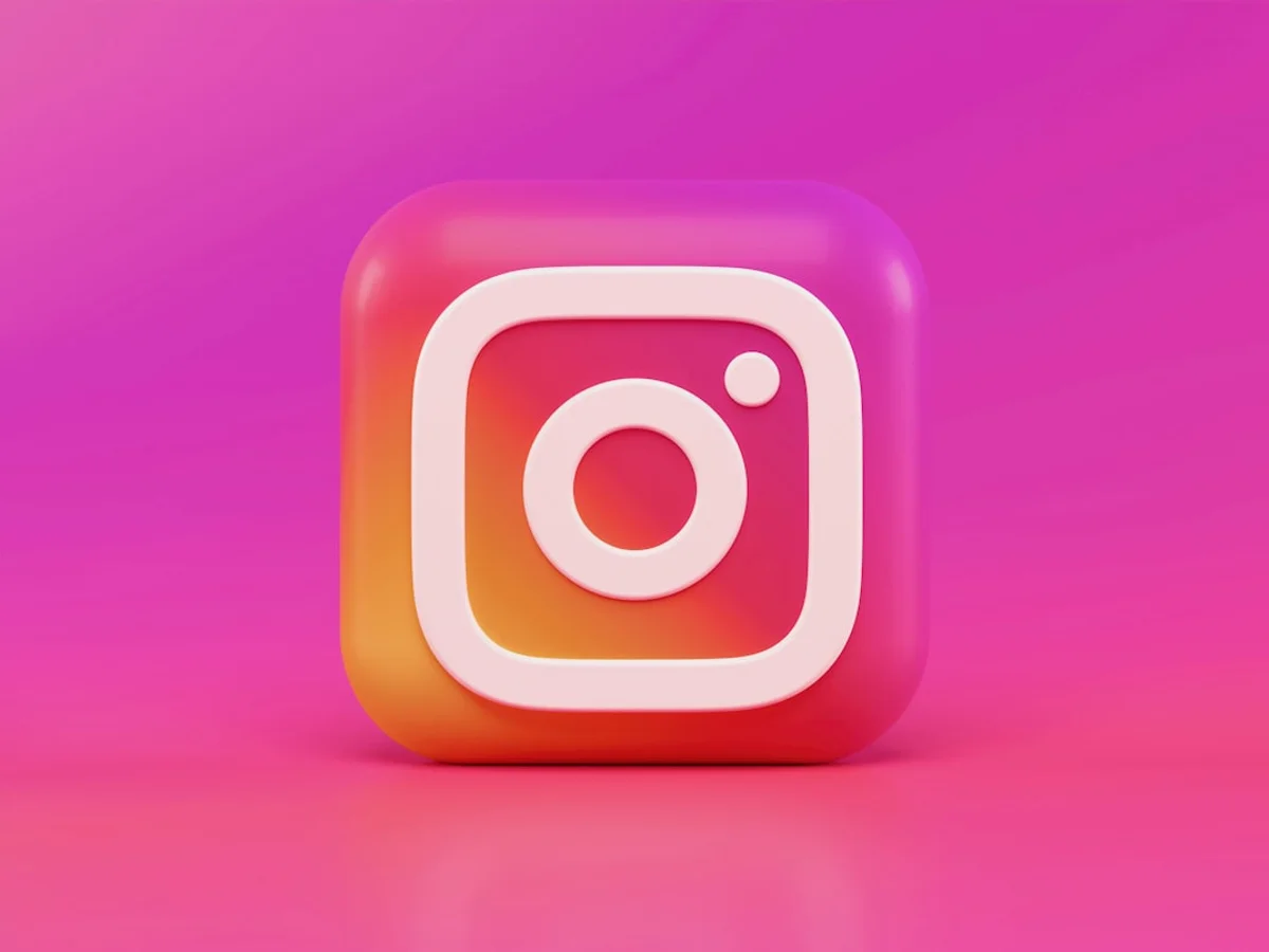 Close-up of an Instagram comment thread on a smartphone held over a desk